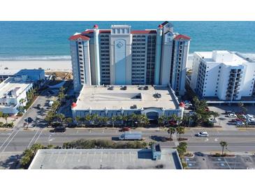 Stunning aerial view of beachfront condominium complex with parking, palm trees, and ocean backdrop at 2401 S Ocean Blvd. # 971, Myrtle Beach, SC 29577