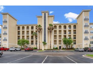 A beautiful condo building with a parking lot, palm trees, and arched windows on a bright sunny day at 265 Venice Way # I-402, Myrtle Beach, SC 29577