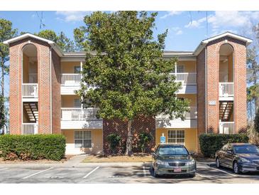 Inviting multi-story condo building with brick accents and a well-maintained landscaped exterior at 4247 Villas Dr. # 406, Little River, SC 29566