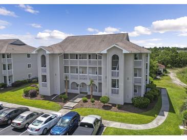 Low angle view of condominium featuring multiple stories, balconies, and landscaping at 4405 Eastport Blvd. # D-8, Little River, SC 29566