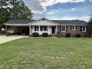 Charming one-story brick home with a well-maintained lawn and a covered parking area at 506 Byrnes Circle, Johnsonville, SC 29555