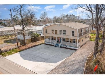 Spacious home featuring a large concrete driveway and covered front porches at 613 Calhoun Dr., Murrells Inlet, SC 29576