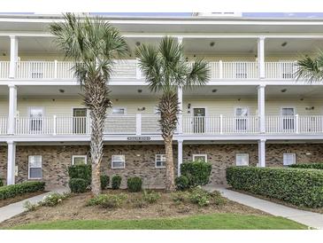 Inviting condo exterior with lovely, white balconies, brick accents, and meticulously maintained landscaping at 6253 Catalina Dr. # 921, North Myrtle Beach, SC 29582