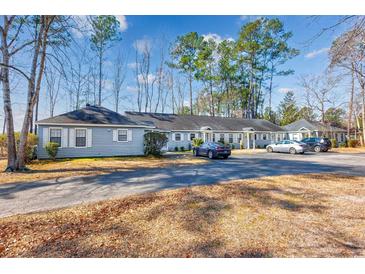 Charming one-story home with neutral siding, ample parking, and lush trees at 6839 Blue Heron Blvd. # 105, Myrtle Beach, SC 29588