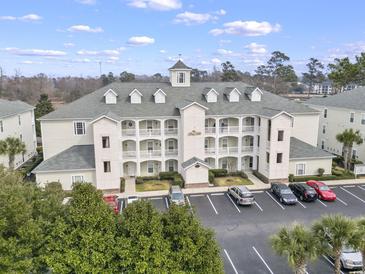 Exterior of a condominium building featuring multiple floors, balconies, and ample parking at 1017 World Tour Blvd. # 206, Myrtle Beach, SC 29579