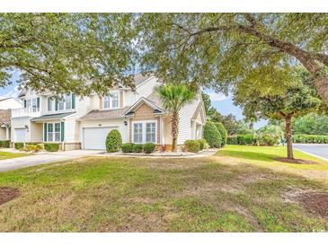 Charming two-story home featuring a well-manicured lawn, attached garage, and tasteful landscaping at 307 River Rock Ln. # 906, Murrells Inlet, SC 29576