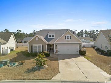 Charming single-story home with neutral siding, well-manicured lawn and a two-car garage at 556 Cedar Lakes Dr., Little River, SC 29566