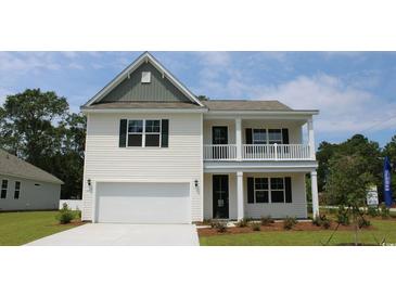Charming two-story home showcasing a porch, two-car garage, and manicured lawn at 7071 Shooting Star Way, Myrtle Beach, SC 29579