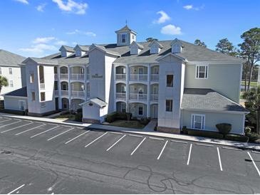 Exterior of condo building showing facade, balconies, and parking area on a sunny day at 1009 World Tour Blvd. # 103, Myrtle Beach, SC 29579