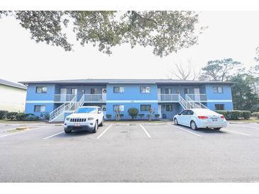 Blue condo building with white railings and stairs leading to each unit, set in a parking lot at 1301 Pridgen Rd. # 1101, Myrtle Beach, SC 29577