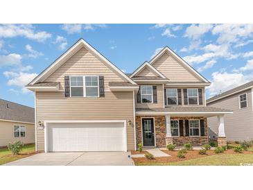 Two-story home with tan siding, stone accents, a two-car garage, and a well-manicured lawn at 1813 Brook Park Pl., Conway, SC 29526