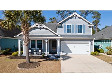 Charming two-story home with a well-manicured lawn, blue shutters, and a welcoming front porch at 2049 Oxford St., Myrtle Beach, SC 29577