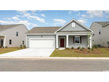 Charming single-story home with gray siding, a two-car garage, and a well-maintained front yard at 230 Carver Willow Dr., Loris, SC 29569