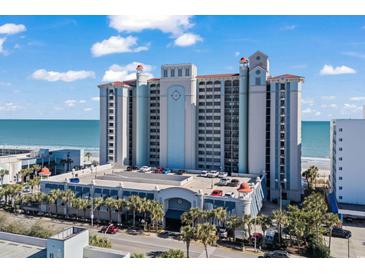 A multi-story hotel with parking garage access, palm trees, beach and ocean views under a sunny sky at 2311 S Ocean Blvd. # 771, Myrtle Beach, SC 29577