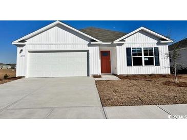 Charming single-Gathering home with a two-car garage, a red door, and bright white siding at 3866 Lady Bug Dr., Shallotte, NC 28470