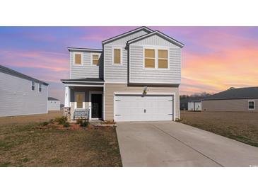 Two-story home featuring white siding, an attached two-car garage, and a well-maintained front lawn at 723 Joywood Dr., Longs, SC 29568