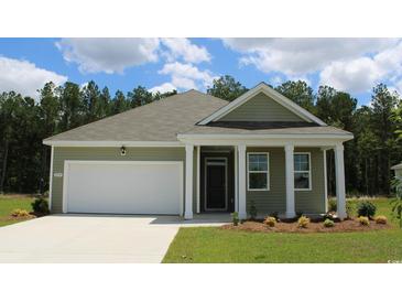 Charming single-story home with green siding, white trim, a two-car garage, and manicured landscaping at 8072 Bear Claw Way, Conway, SC 29526