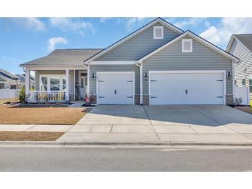 Charming home with a two-car garage, blue siding, and manicured landscaping at 892 Harrison Mill St., Myrtle Beach, SC 29579