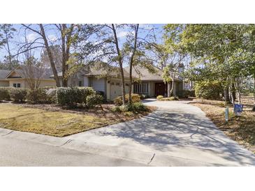 Charming single-story home with mature trees, lush landscaping, and a circular driveway at 1820 Spinnaker Dr., North Myrtle Beach, SC 29582