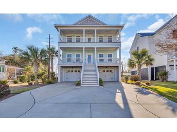 Charming coastal home featuring double porches, a light blue exterior, and a spacious driveway at 186 Cayman Loop, Pawleys Island, SC 29585