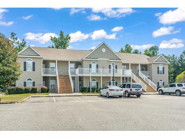 Attractive two-story condo building with private balconies and ample parking space on a sunny day at 210 Portsmith Dr. # 2, Myrtle Beach, SC 29588