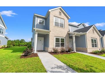 Charming two-story townhome with a combination of brick and siding and a well-manicured lawn and walkway at 344 Kiskadee Loop # A, Conway, SC 29526