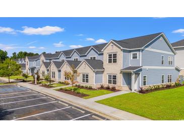 New townhomes with brick and vinyl exterior, neat landscaping, ample parking, and sidewalks under blue sky at 344 Kiskadee Loop # F, Conway, SC 29526