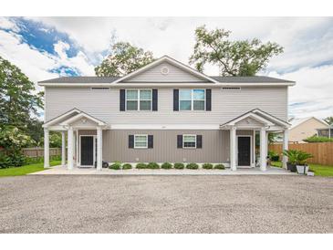 Charming two-story duplex with gray siding, black shutters, and well-maintained landscaping at 3952 Murrells Inlet Rd., Murrells Inlet, SC 29576