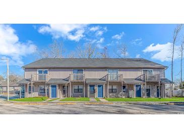 Two-story townhome exterior featuring individual balconies, blue doors, and well-maintained landscaping under a bright sky at 110 Horizon River Dr. # I-2, Myrtle Beach, SC 29588
