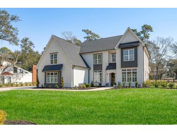 Stunning two-story home featuring a modern farmhouse design, manicured lawn, and sophisticated landscaping at 208 Green Lake Dr., Myrtle Beach, SC 29572