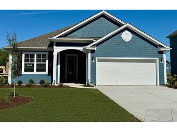 Charming blue home features a two-car garage and manicured lawn at 399 Wingspan Ct., Myrtle Beach, SC 29588