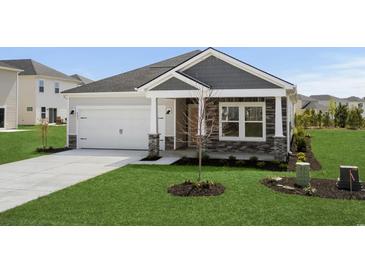 Charming single-story home featuring stone accents, a two-car garage, and well-manicured lawn at 4295 Falls Oaks St., Myrtle Beach, SC 29579