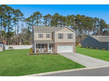Charming two-story home with a brick-accented facade, manicured lawn, and a two-car garage at 55 Porch Ln., Pawleys Island, SC 29585