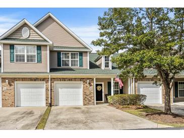 Charming townhome with brick accents, attached garage, and manicured landscaping under a sunny blue sky at 712 Painted Bunting Dr. # B, Murrells Inlet, SC 29576