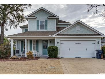 Charming two-story home with a well-manicured lawn, attached two-car garage, and a welcoming front porch at 405 Banyan Place, North Myrtle Beach, SC 29582