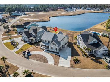 Stunning aerial view of home on waterfront lot, featuring lush landscaping and private driveway at 481 Starlit Way, Myrtle Beach, SC 29579