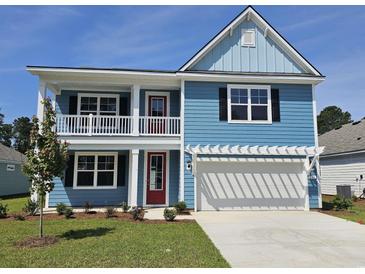 Charming two-story blue home with a spacious two-car garage and landscaped front yard under a clear blue sky at 518 Haven View Way, Murrells Inlet, SC 29576