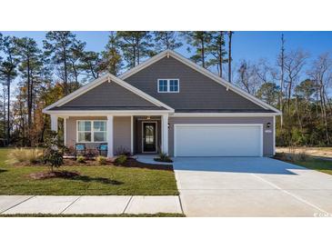 Charming one-story home featuring a gray exterior, manicured lawn, and a two-car garage at 585 Haven View Way, Murrells Inlet, SC 29576