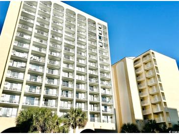 A full view of a multi-story condo building featuring balconies and palm trees against a clear sky at 1207 S Ocean Blvd. # 51104, Myrtle Beach, SC 29577