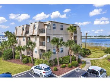 Exterior view of building with palm trees, green lawn and partial parking area under a blue cloudy sky at 1582 S Waccamaw Dr. # 44, Murrells Inlet, SC 29576