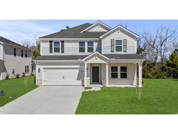 Two-story home showing a well-maintained lawn, a two-car garage, and a stylish mix of siding and brick at 2052 Copper Creek Ct., Longs, SC 29568