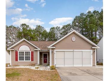 Charming single-story home featuring a well-maintained lawn, two-car garage, and inviting front porch at 310 Junco Circle, Longs, SC 29568