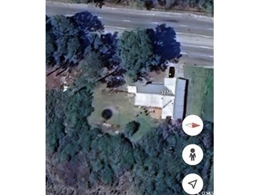 An aerial view of a charming house with a lush, tree-filled yard and a unique circular feature in the garden at 3256 S Highway 41-51, Hemingway, SC 29554