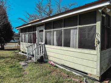 Enclosed sunroom with screened windows providing natural light, and a view of the yard at 422 S Magnolia Ave., Andrews, SC 29510