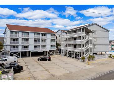 This exterior view showcases a multi-story condo with ample parking beneath the building at 625 N Waccamaw Dr. # 102, Murrells Inlet, SC 29576