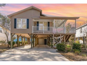 Charming beach home with stilt foundation, covered porch, and driveway at 813 Starboard Ct., Murrells Inlet, SC 29576