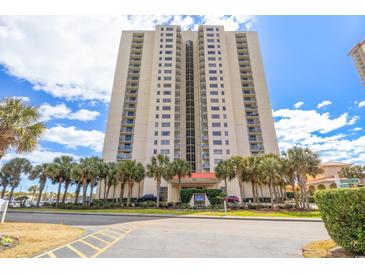 High-rise condo building boasts lush landscaping with tropical palm trees along a scenic road near the beach at 8560 Queensway Blvd. # 1206, Myrtle Beach, SC 29572