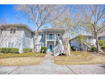 Charming condo with light-gray siding, stairway to the second floor, and lush landscaping at 1221 Tidewater Dr. # 1721, North Myrtle Beach, SC 29582