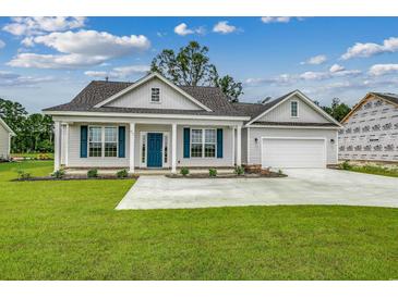Charming single-story home with light gray siding, blue shutters, manicured lawn, and attached two-car garage at 227 Six Mile Creek Dr., Georgetown, SC 29440
