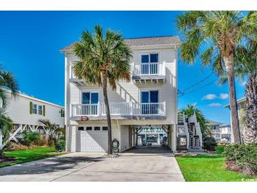 Charming coastal home with white siding, balconies, ground-level parking and lush landscaping at 321 52Nd Ave. N, North Myrtle Beach, SC 29582